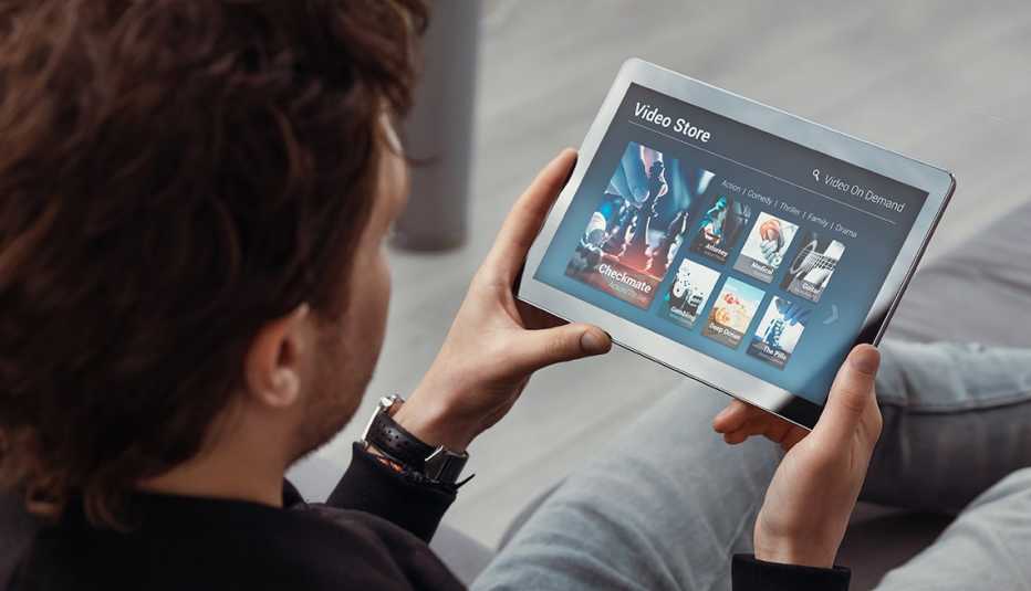 Man using tablet for watching VOD service. Video On Demand television concept