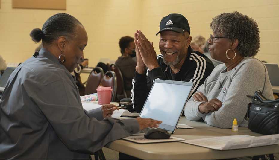Photo of African American man smiling with his wife getting his taxes done at a site for free by AARP Foundation