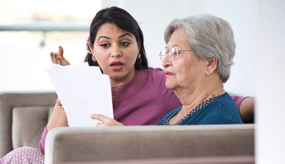  Mother and her adult daughter looking at bills