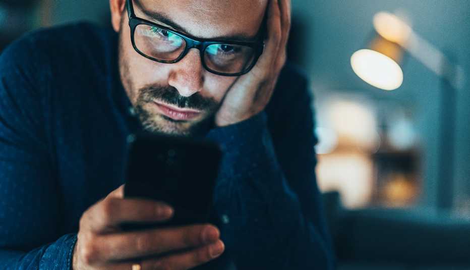 A man addicted to social media texting in the dusk at home