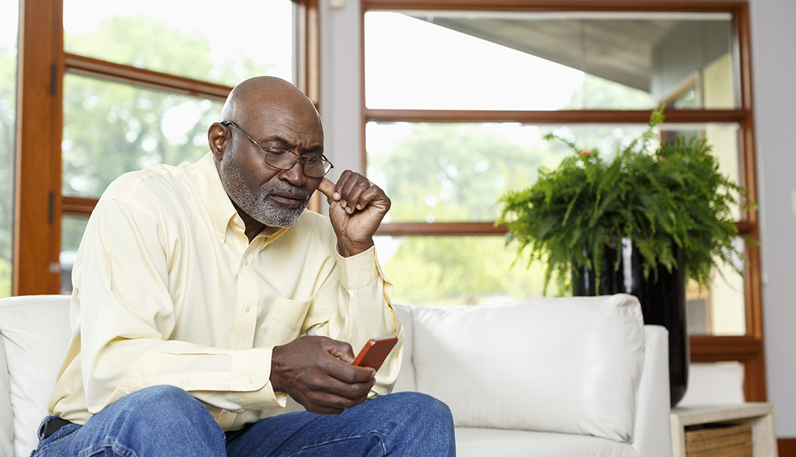 Man texting with cell phone on sofa