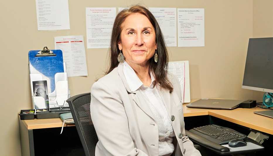 Margaret Locke poses for a photograph in the Denver offices of the AARP Fraud Watch Network Helpline on April 06, 2023. Locke has volunteered for more than five years. 
