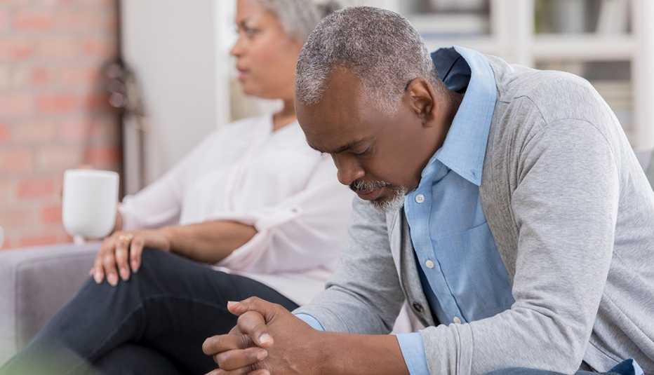 a couple looks sad sitting on a sofa