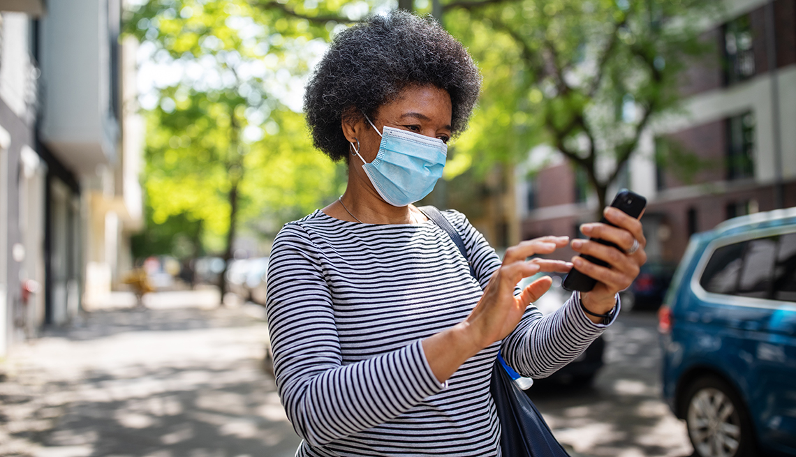 Woman wearing a mask answering a phone call