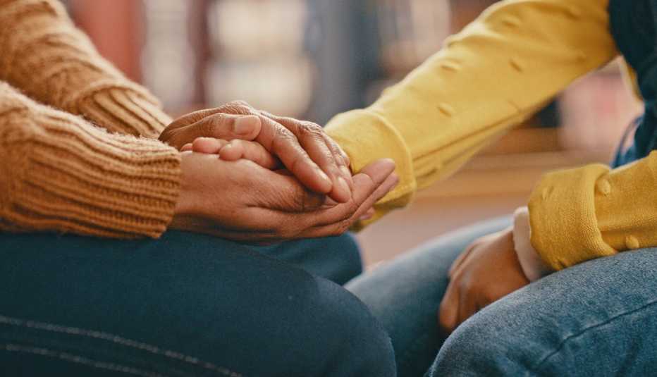 two people holding hands in support
