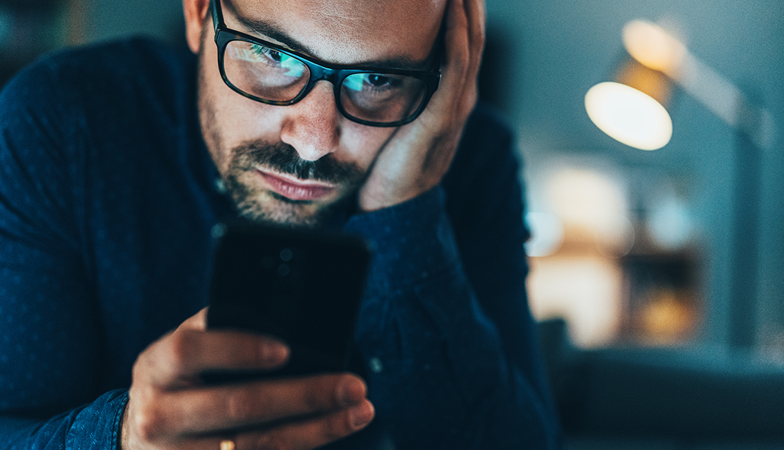 A man addicted to social media texting in the dusk at home