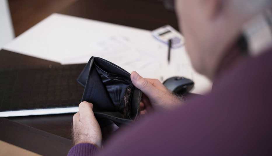 Older adult holding an empty wallet.